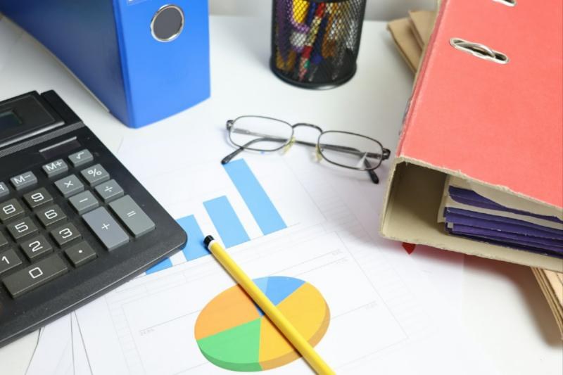 Calculator, financial charts and binders on a desk